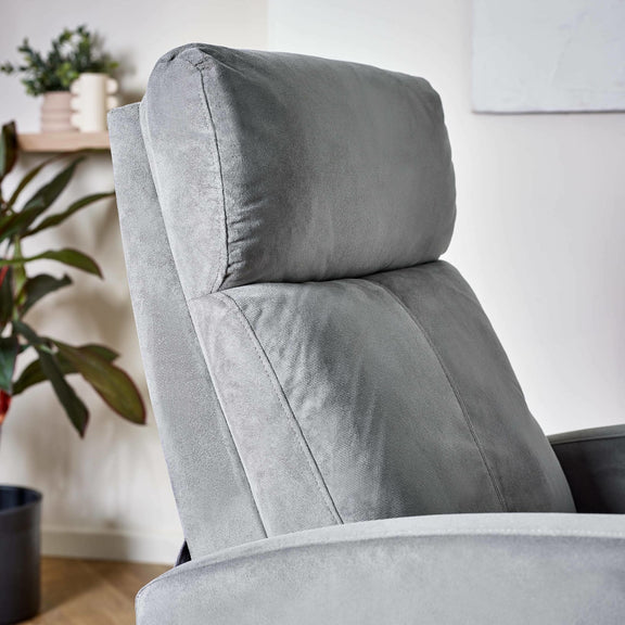Gray recliner chair in a home setting with plants and a white wall.