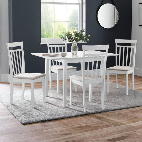 White dining table with four chairs in a room with a window and decorative mirror.