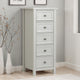 White dresser with four drawers in a room with gray walls and wooden flooring.