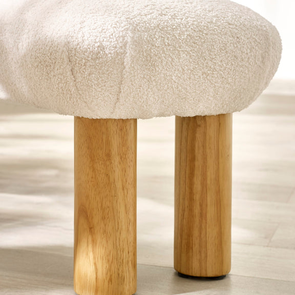Stool with white cushioned top and wooden legs on a light background