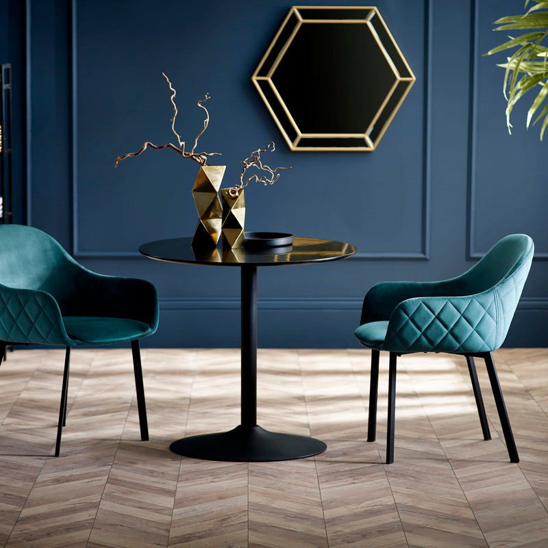 Modern interior with two teal chairs and a black table against a blue wall.