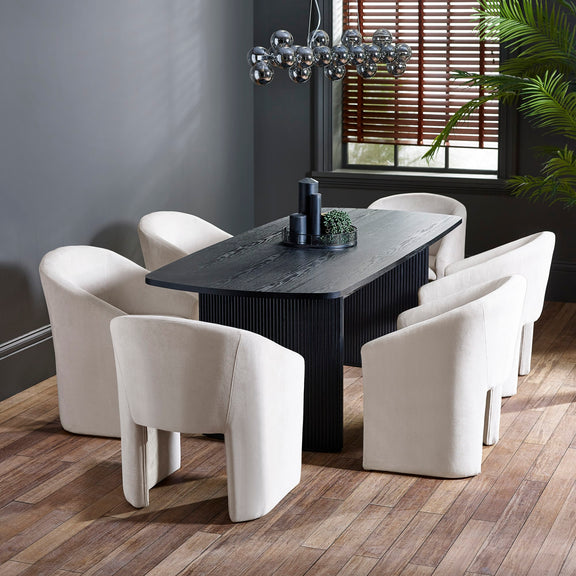 Dining room with a dark wooden table and white chairs on a wooden floor.