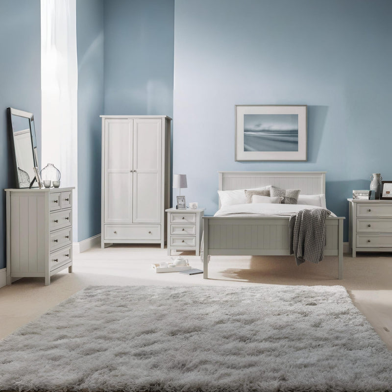 Neatly arranged bedroom with light gray furniture against a blue wall.