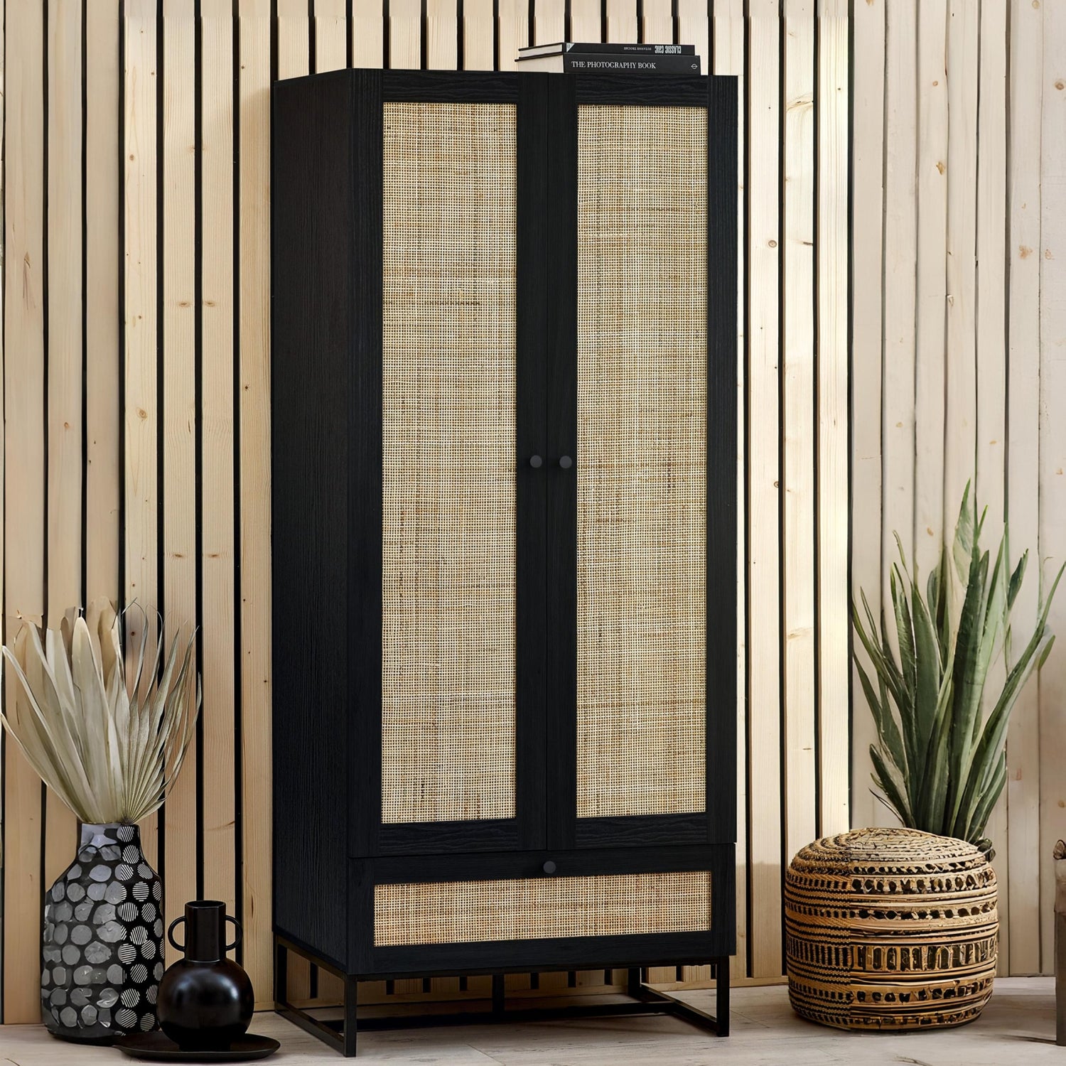 Black cabinet with woven doors in a room with plants and decor