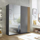 Modern wardrobe with glass panels in a bedroom setting