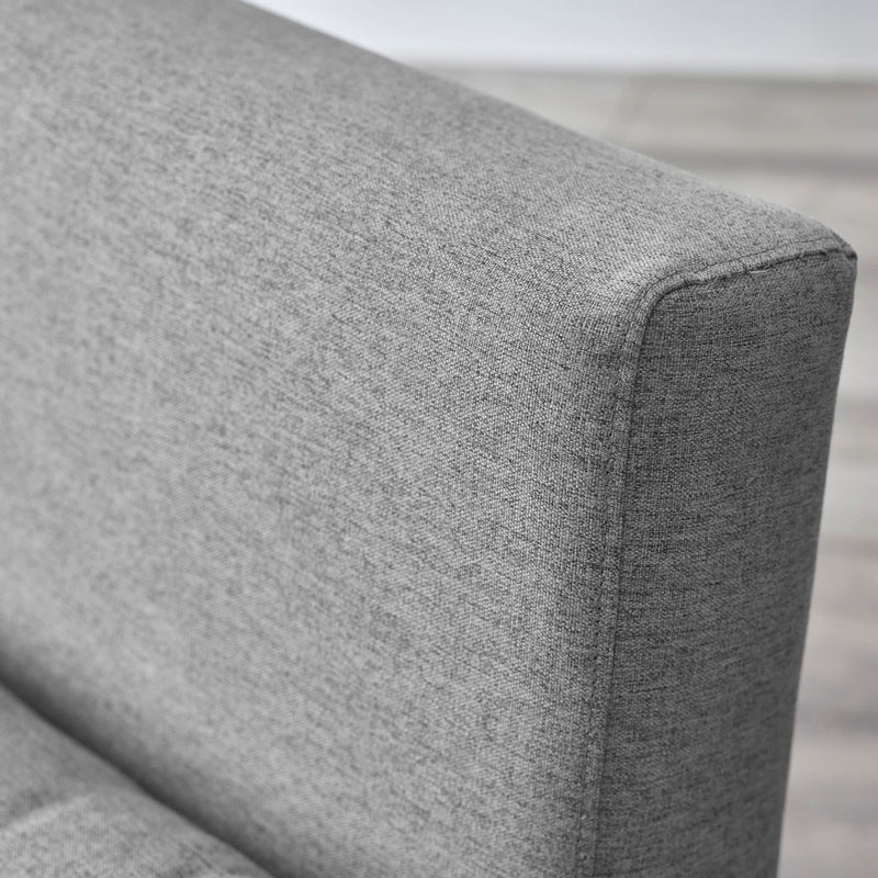 Gray fabric armrest of a sofa with a blurred background