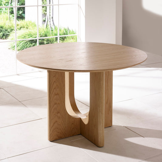 Wooden dining table in a bright room with large windows