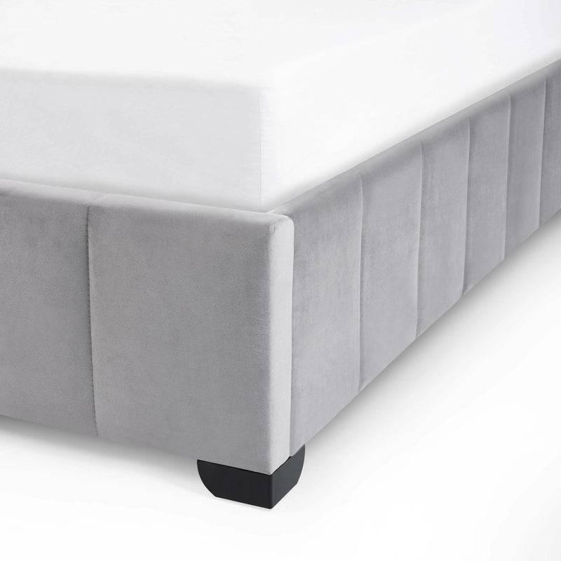 Gray upholstered bed frame with a white mattress on a white background