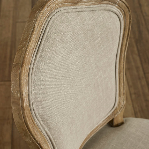 Close-up of a chair with wooden frame and beige fabric seat.