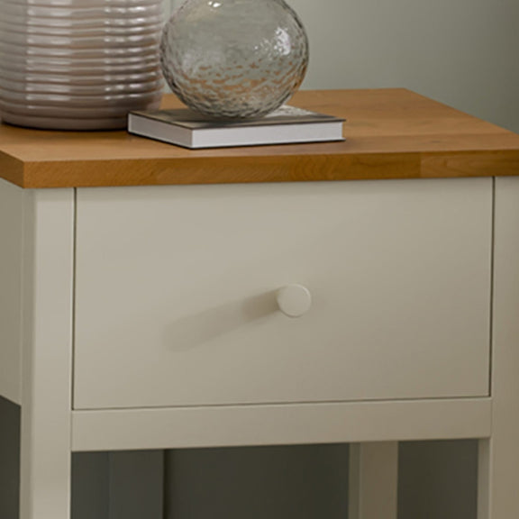 Light gray side table with a wooden top featuring decorative items.