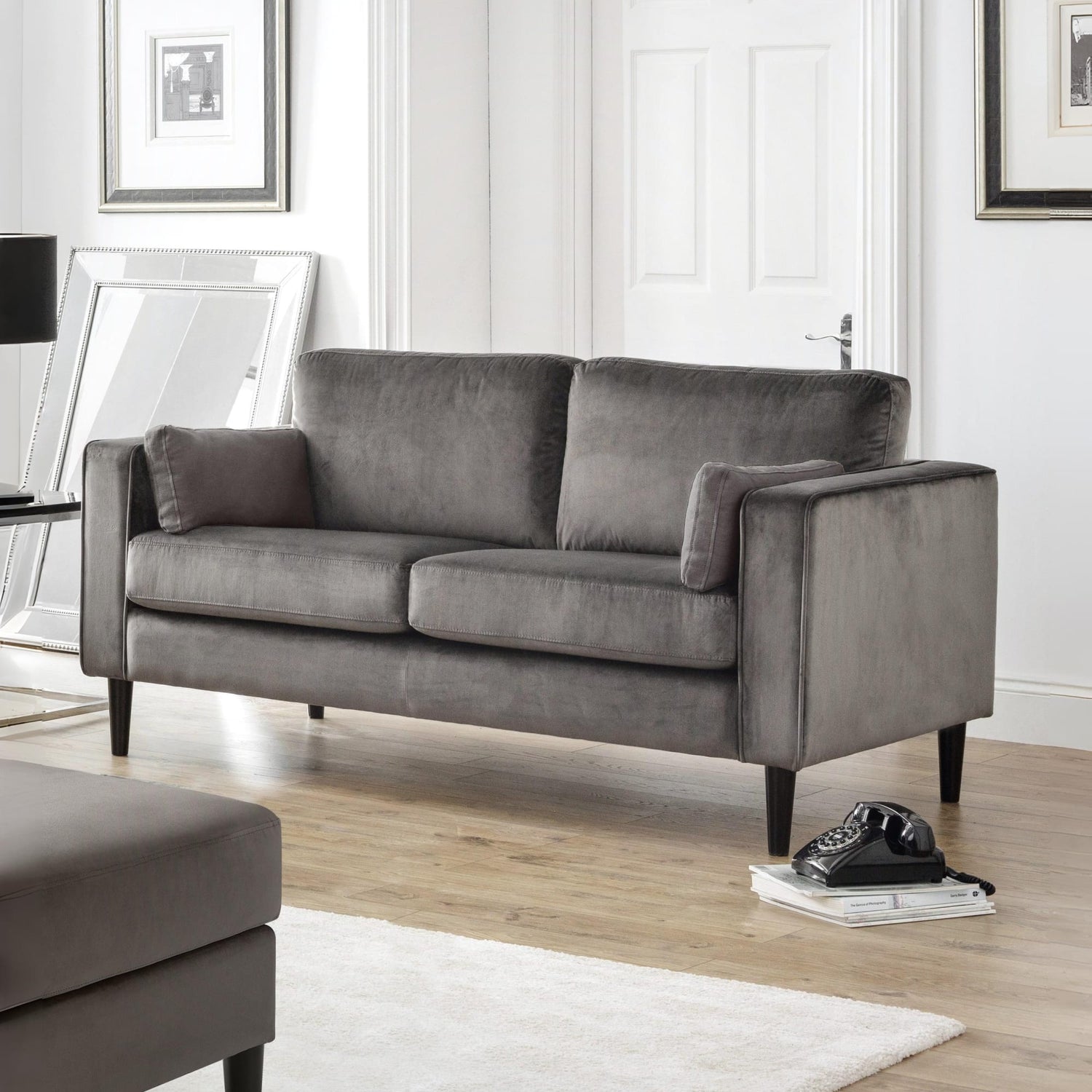 Gray sofa in a living room setting with a rug and decor items.