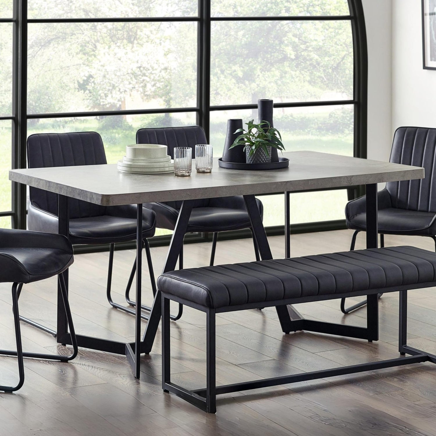 Dining room with a table, chairs, and bench in a modern setting.