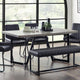 Dining room with a table, chairs, and bench in a modern setting.