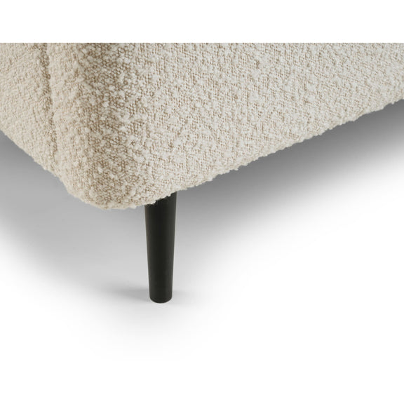 Close-up of a textured beige sofa corner with a black leg on a white background