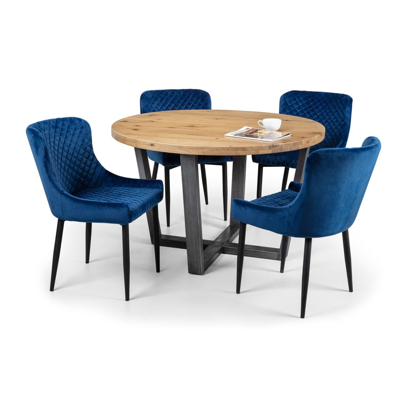 Round wooden dining table with four blue chairs on a white background