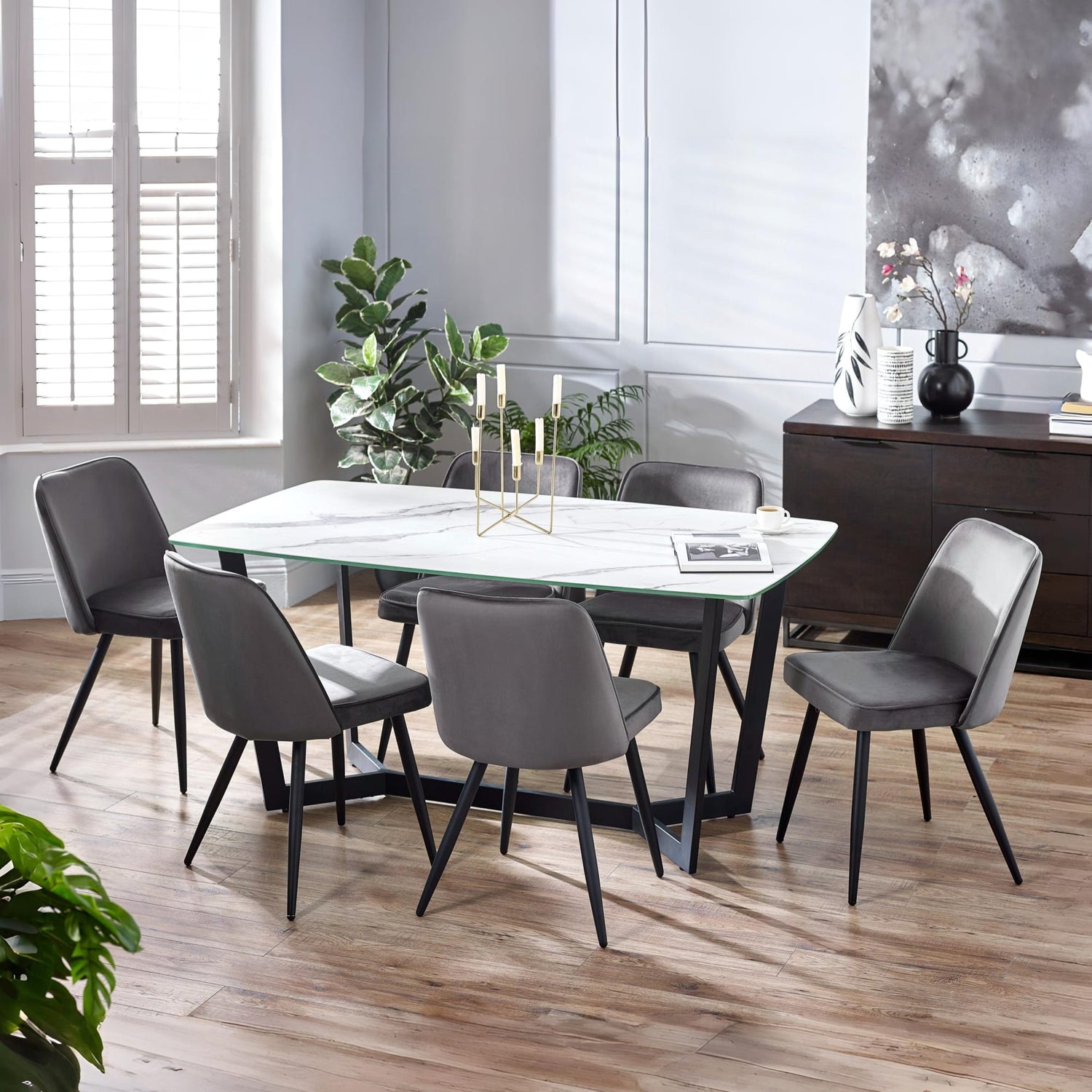 Dining room with a marble table and gray chairs in a modern setting.