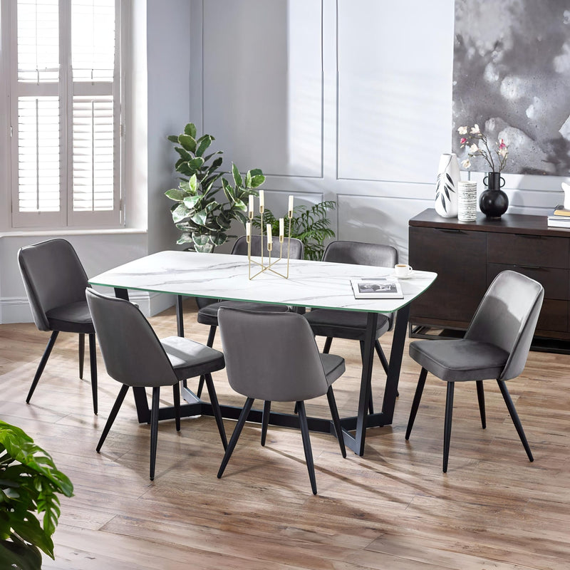 Dining room with a marble table and gray chairs in a modern setting.