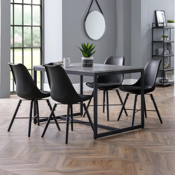 Dining area with a table and four black chairs in a modern interior setting.