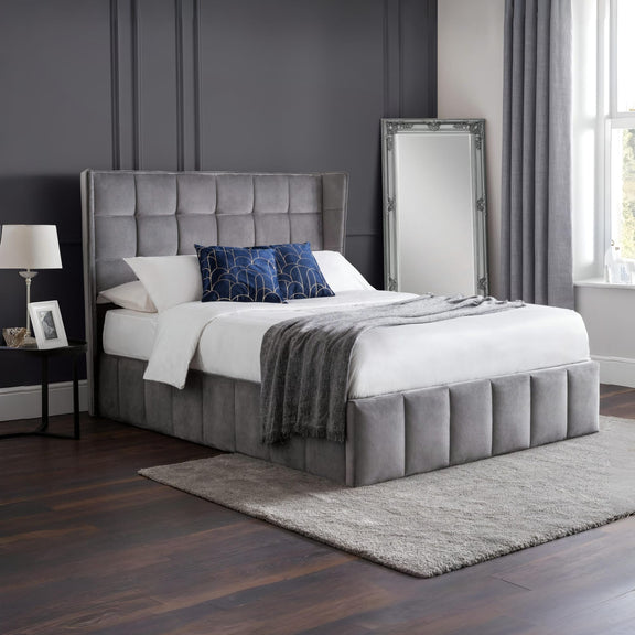 Gray upholstered bed with white bedding in a bedroom setting.