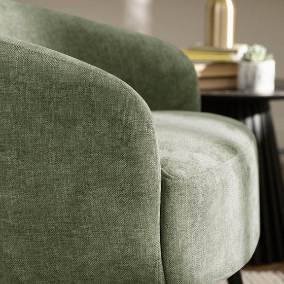 Close-up of a green upholstered chair with a blurred background