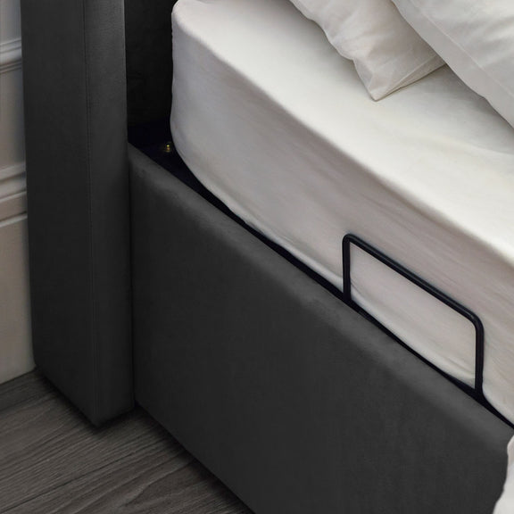 Gray bed frame with white mattress and pillows in a room setting