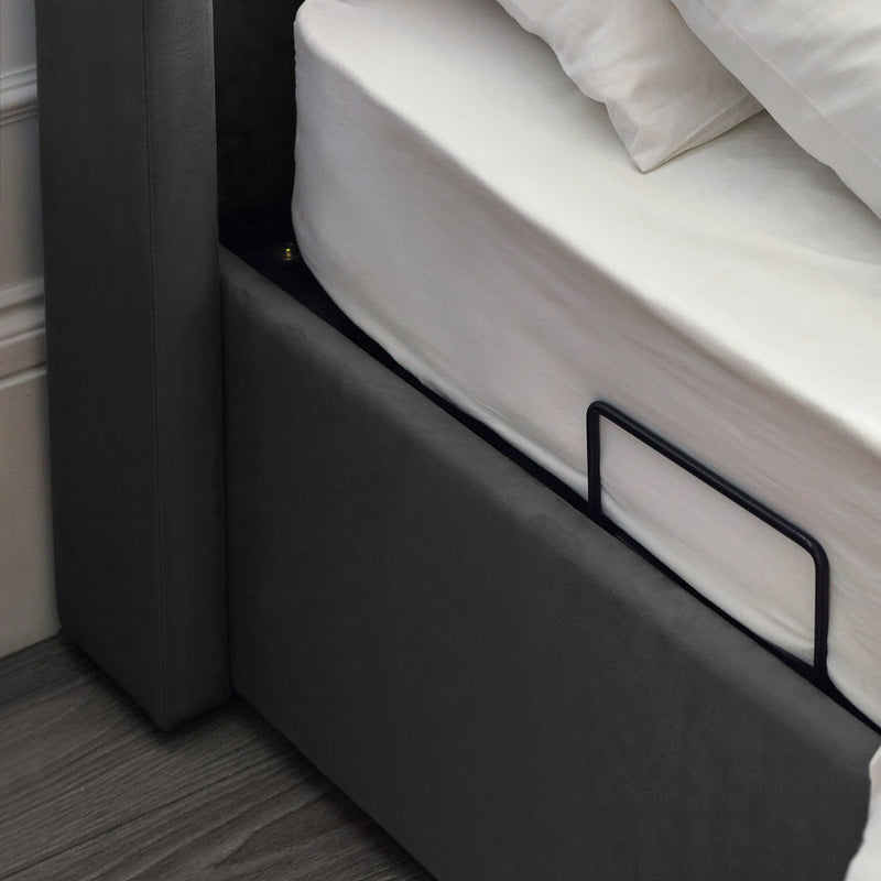 Gray bed frame with white mattress and pillows in a room setting