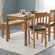 Wooden dining table with chairs and a bench on a light rug.