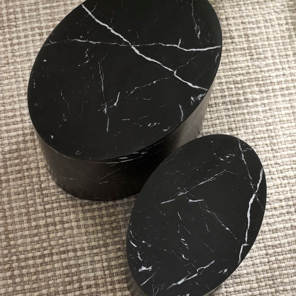 Black marble cylindrical objects on a textured surface