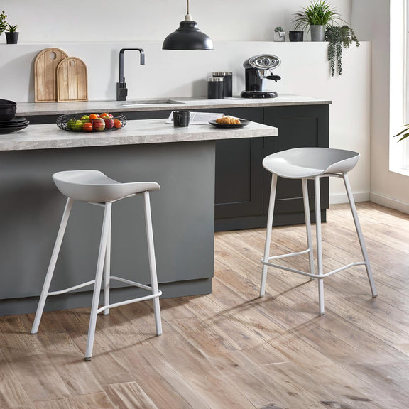 Modern kitchen with gray island, stools, and various kitchen appliances.