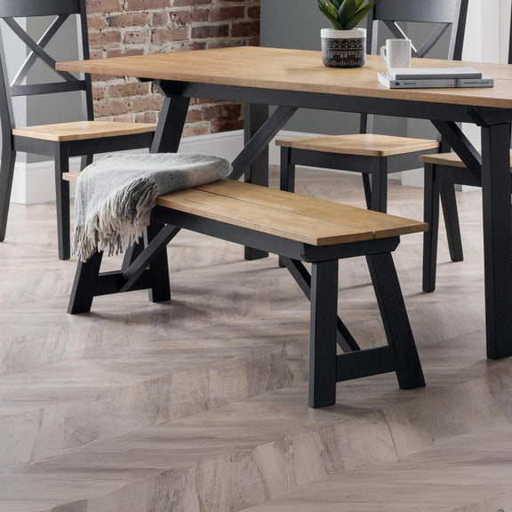 Dining table with benches and a plant in a modern interior setting.