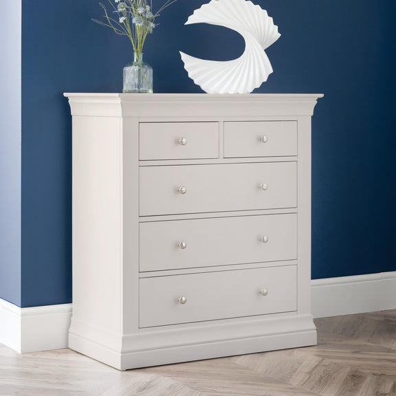Gray dresser with four drawers against a blue wall