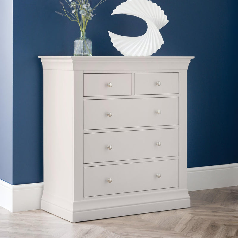 Gray dresser with four drawers against a blue wall