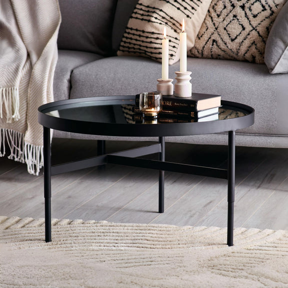 Black coffee table with decorative items in a living room setting