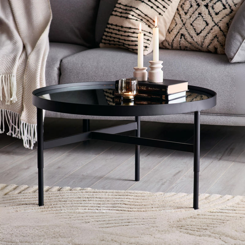 Black coffee table with decorative items in a living room setting