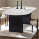 Dining table with black cylindrical base and white marble top in a room setting.