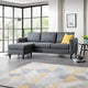 Gray sectional sofa with a yellow pillow in a living room setting.
