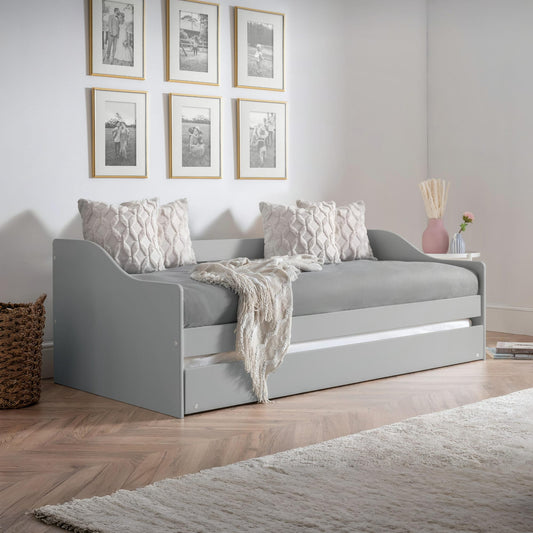 Gray sofa bed in a room with framed pictures on the wall.