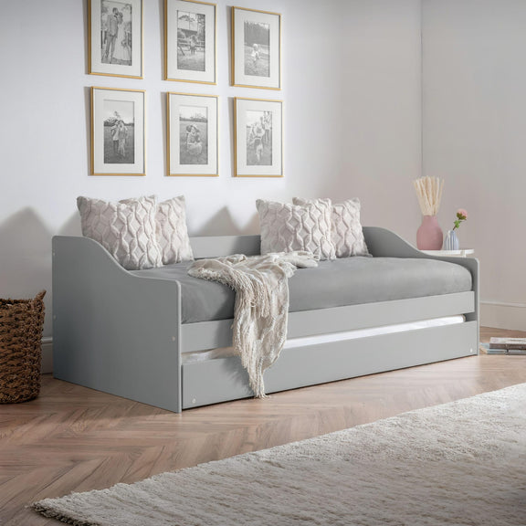 Gray sofa bed in a room with framed pictures on the wall.