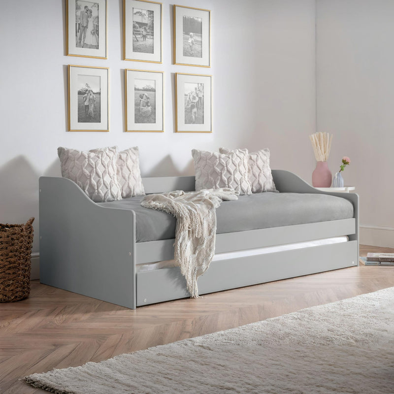 Gray sofa bed in a room with framed pictures on the wall.