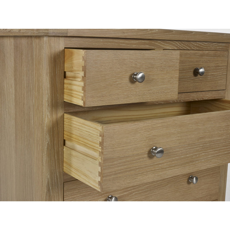 Wooden dresser with three drawers and metal handles on a white background