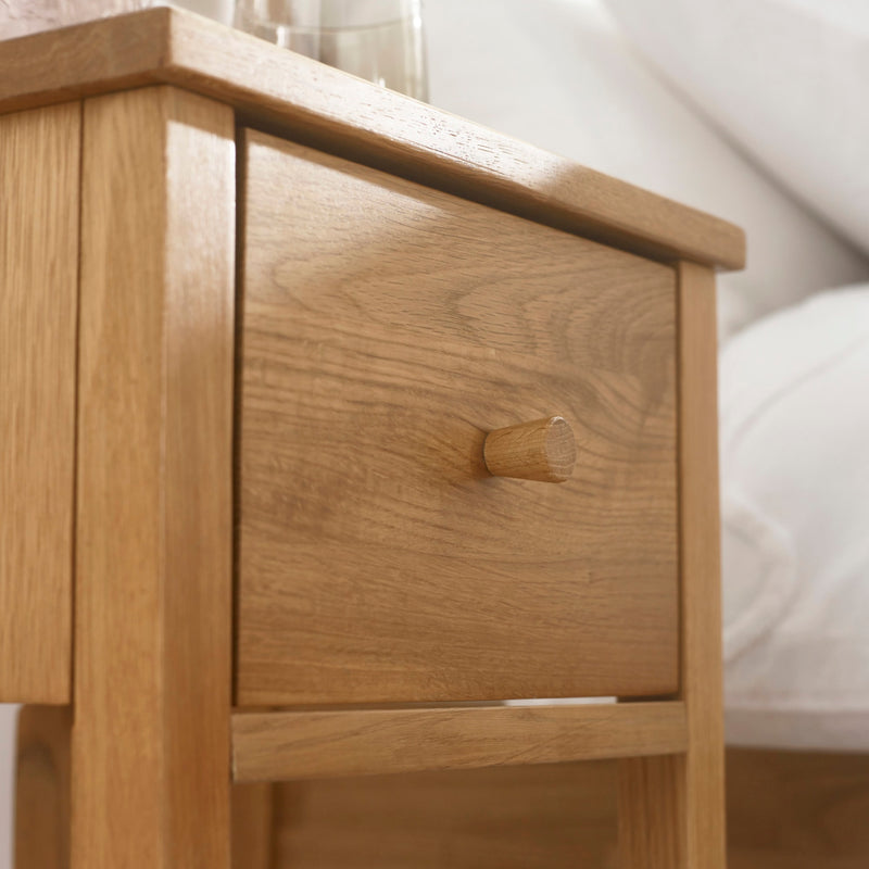 Wooden nightstand with a drawer in a bedroom setting