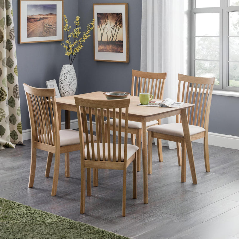 Dining room with wooden table and chairs against a gray wall.