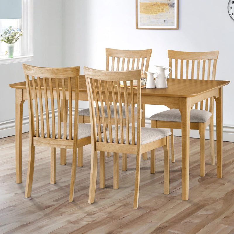 Dining room with wooden table and chairs on a wooden floor.
