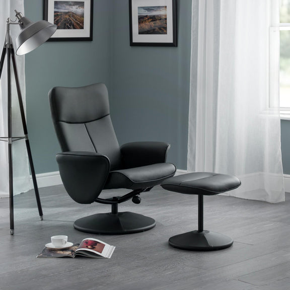 Black leather recliner chair with ottoman in a room with a lamp and window.