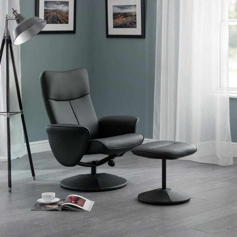 Black leather recliner chair with ottoman in a room with a lamp and window.