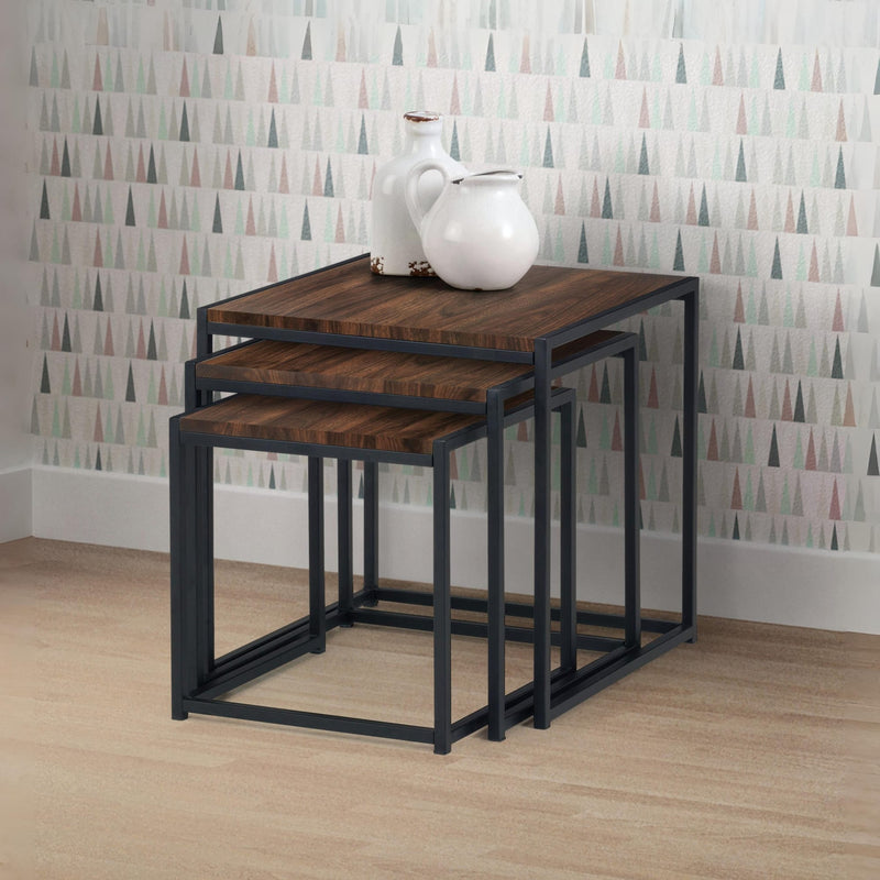 Set of three nesting tables with wooden tops and black metal frames against a patterned wall.