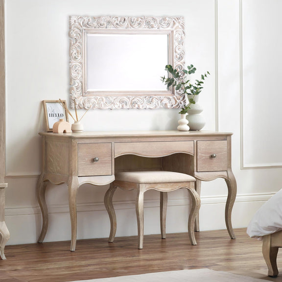 Wooden vanity table with mirror and stool in a room setting