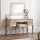 Wooden vanity table with mirror and stool in a room setting