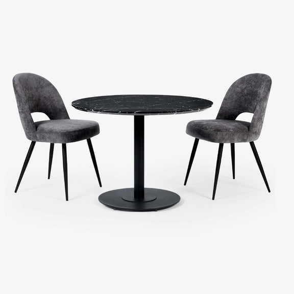 Round black marble table with two gray upholstered chairs on a white background
