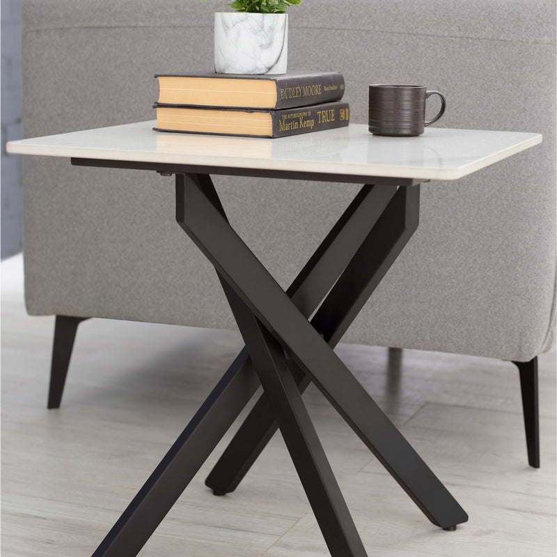 Small table with marble top and black metal legs, featuring books and a mug in a room setting.
